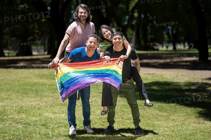 Group of latin friends holding the LGBT flag