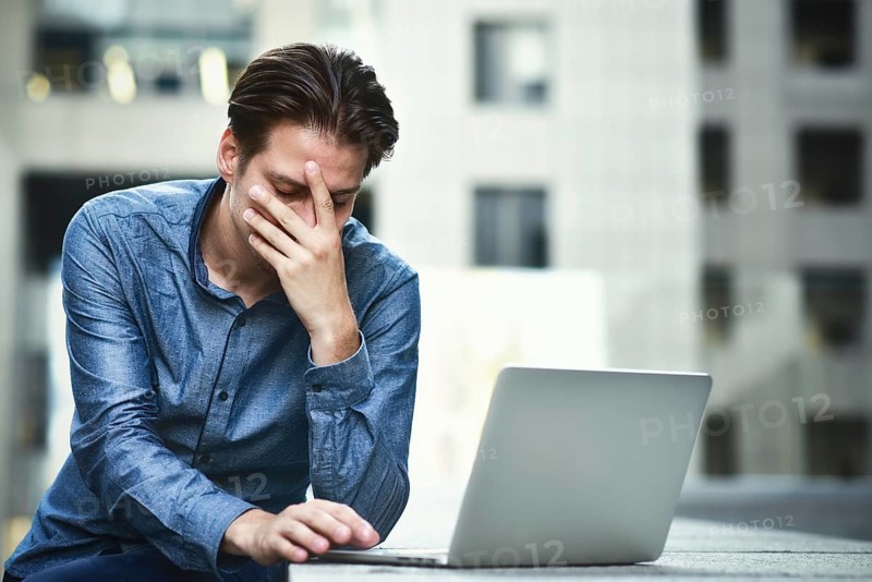 Stressed businessman after project failure. Confused young man frustrated by online problem