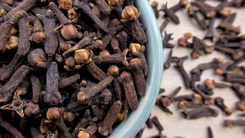 Aromatic Cloves in a Light Blue Bowl with Blurred Background, Close-Up Shot, Top Flat lay