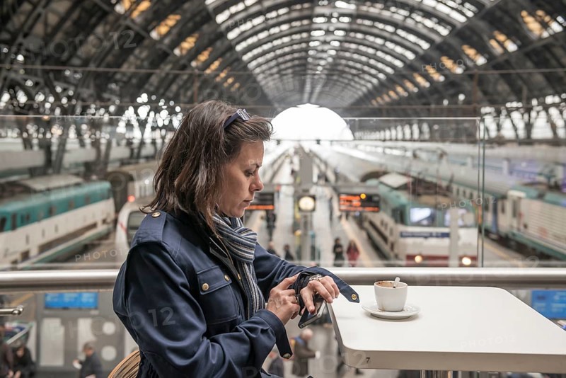 Woman in a Restaurant Drinking Coffee and Looking at Her Watch in Railroad Station in Milan, Lombardy, Italy, Europe