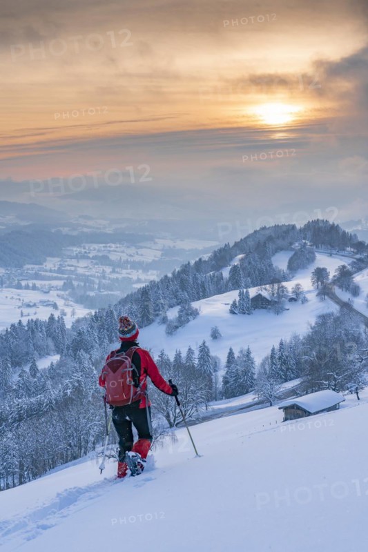 Pretty active senior woman snowshoeing in the Allgäu Alps near Oberstaufen with a view of the Bregenzerwald, Vorarlberg, Austria, Europe