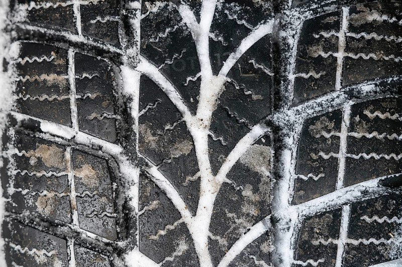 Closeup of car tires in winter. Winter tire with snow