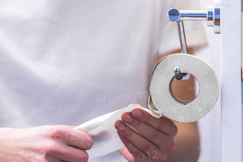 Hand of a male person using toilet paper