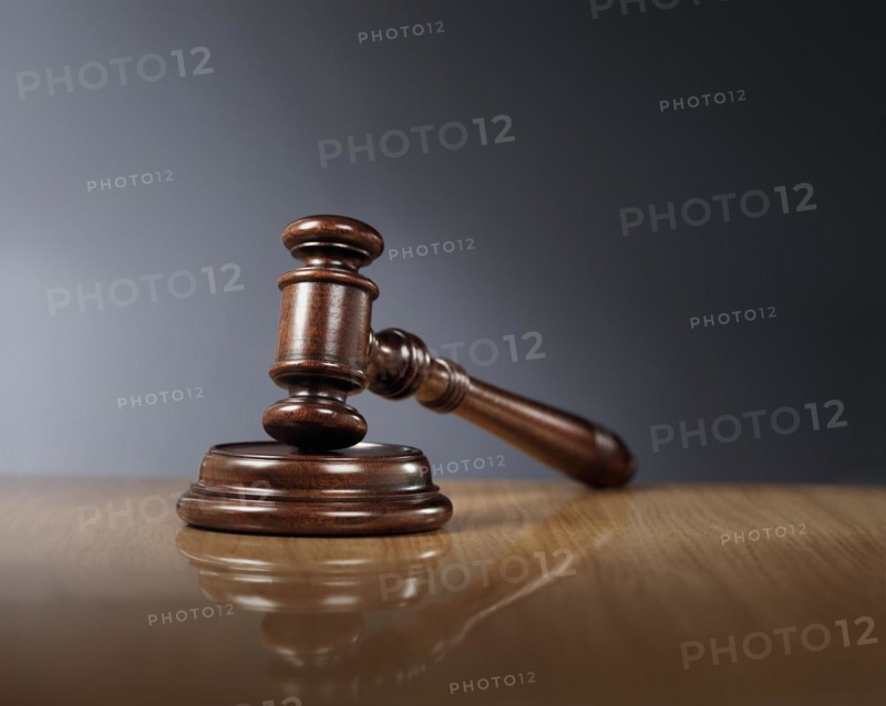 Mahogany wooden gavel on glossy wooden table