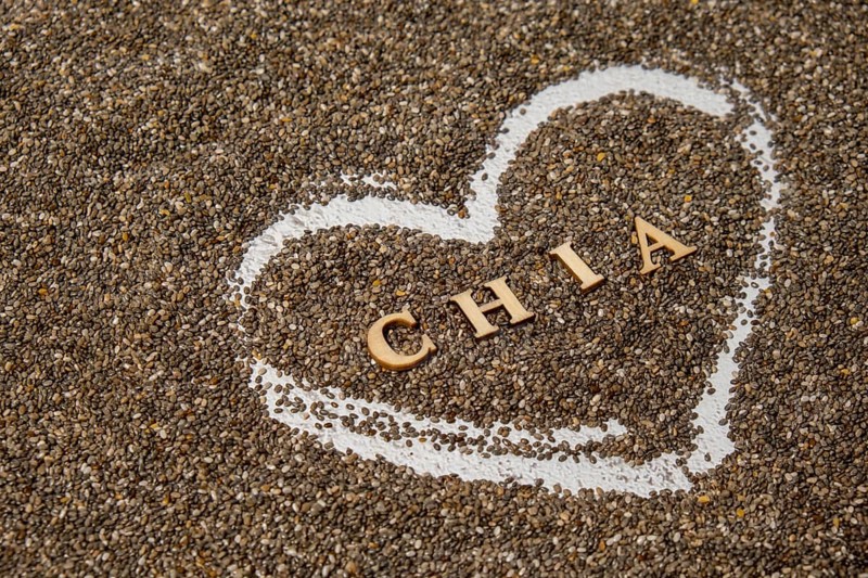 Heart made of chia seeds with word CHIA inside background. Healthy superfood rich in Omega 3 fatty acids. Dry healthy natural ingredient. Vegetarian food favorite dietary products