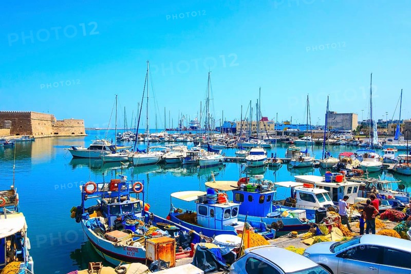 Heraklion, Greece, April 27, 2019: Crete island old harbor with fishing boats and Venetian fortress of Rocca al Mare, Europe