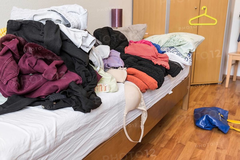 Messy teenager room. Untidy cluttered bed, dirty clothes. Compulsive Hoarding Syndrom