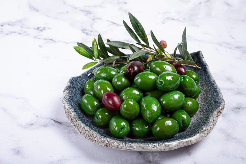 Chalkidiki olives, classic Greek green olives, in a plate, top view, no people