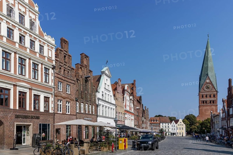 Historic surrounding gabled houses with many shops and restaurants on the square Am Sande in the medieval old town of Lüneburg and St. Johannis church with leaning tower, Hanseatic city of Lüneburg, Lower Saxony, Germany, Europe