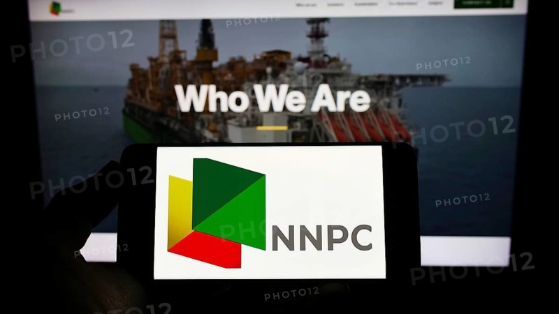 Stuttgart, Germany, 10-03-2022: Person holding smartphone with logo of Nigerian National Petroleum Company Limited (NNPC) on screen in front of web page. Focus on phone display, Europe