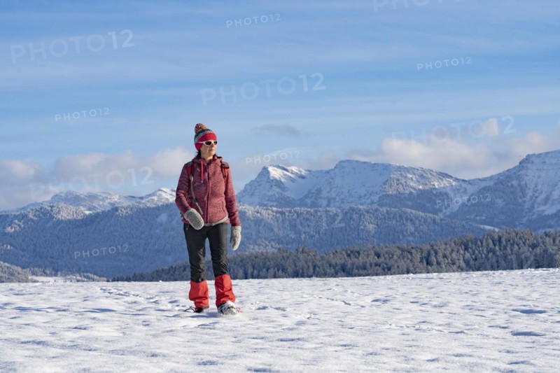 Pretty active senior woman snowshoeing in the Allgäu Alps near Oberstaufen with a view of the Bregenzerwald, Vorarlberg, Austria, Europe