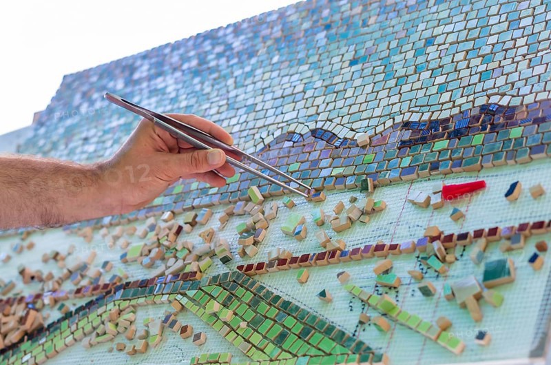 Mosaic as a ceramic or ceramic mosaic. The man organizes design with a tweezers a puzzle of ceramic elements for the construction of ceramic works. Artistic mosaics of terracotta. Bulgaria