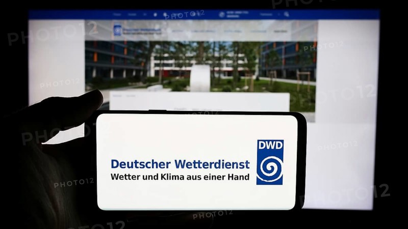 Stuttgart, Germany, 06-06-2024: Person holding cellphone with logo of German meteorological service Deutscher Wetterdienst (DWD) in front of webpage. Focus on phone display, Europe