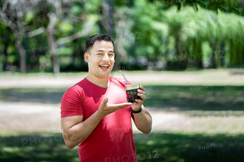 Happy latin man showing his mate tea