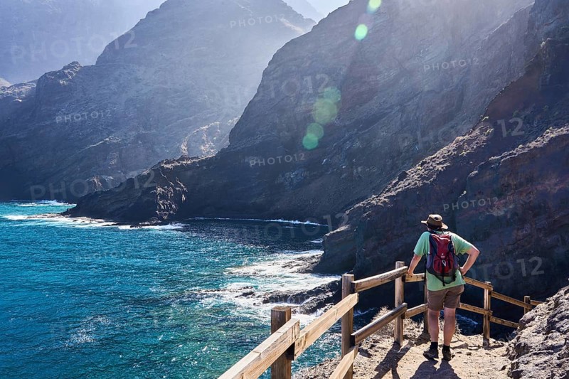 Hikers on the hiking trail from Playa de la Caleta to Punta San Lorenzo, cliffs near Hermigua, La Gomera, Canary Islands, Spain, Europe