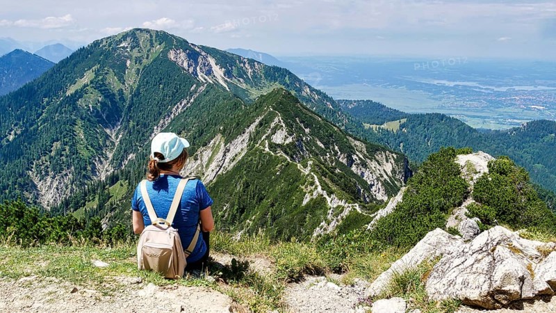 Hiker looks from Herzogstand to the ridge path to Heimgarten