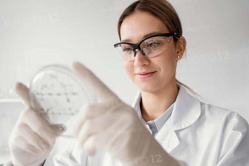Medium shot scientist holding petri dish