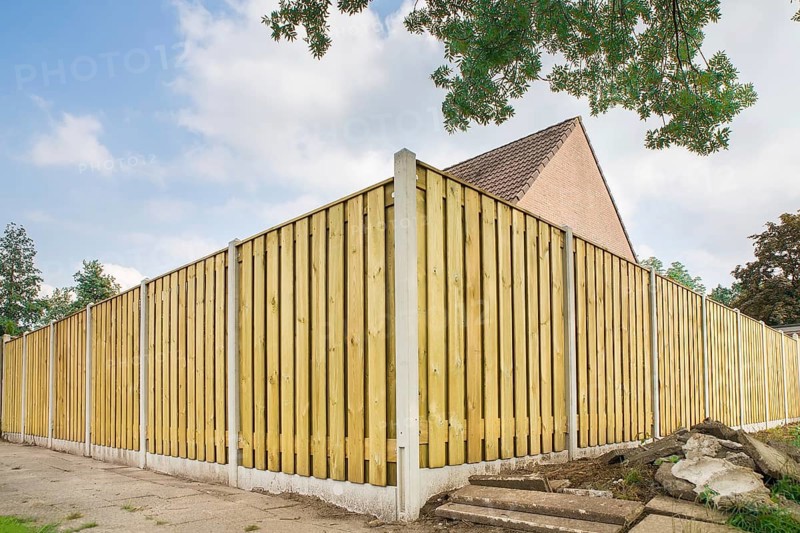 New wooden fence as corner around garden of home