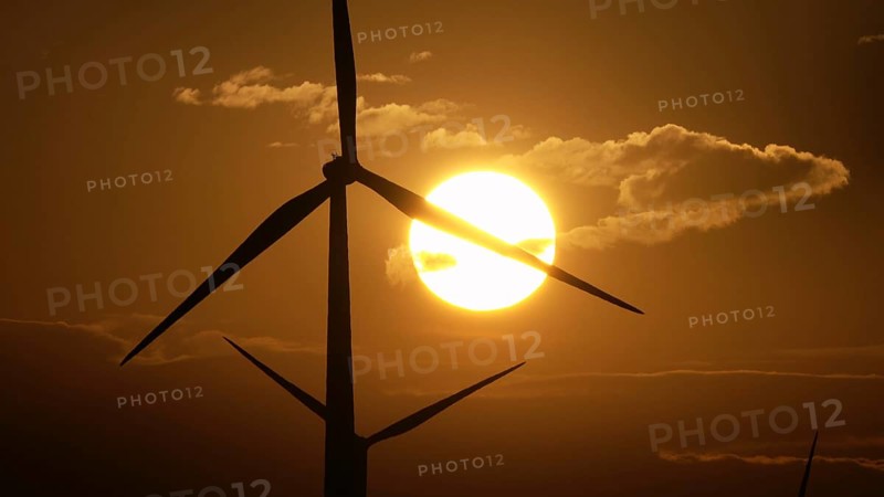 Beautiful sunrise dawn landscape with windmills or wind turbine on wind farm in rotation to generate electricity energy
