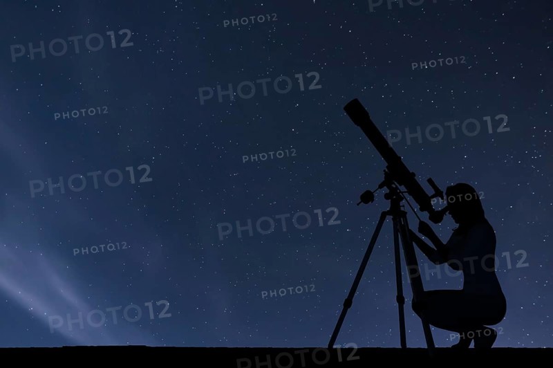 Girl looking at the stars with telescope. Starry night sky