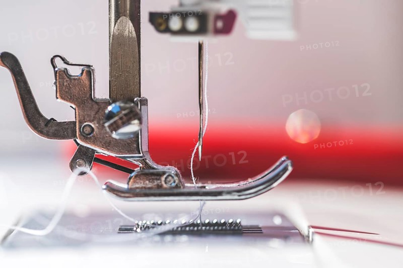 Close up of sewing metal sewing needle with sewing thread