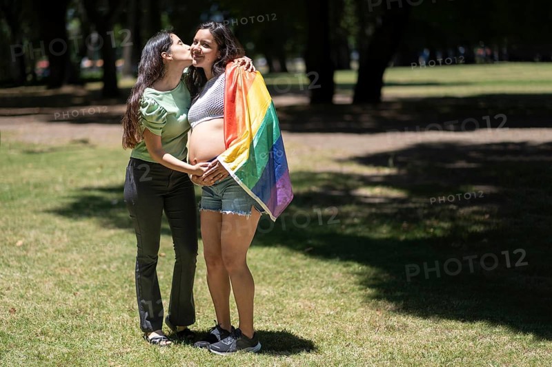 Pregnant latin lesbian couple in a park celebrating LGBT pride