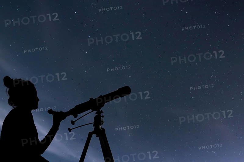 Woman with telescope watching the stars. Stargazing woman and night sky