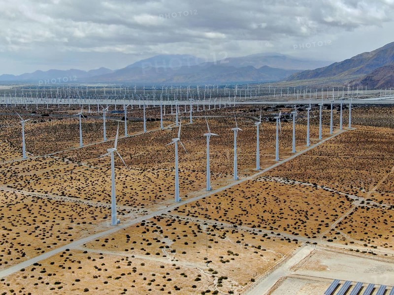 Aerial view of huge array of gigantic wind turbines spreading over the desert in Palm Springs wind farm. California. USA. Aerial view of wind turbines generating electricity