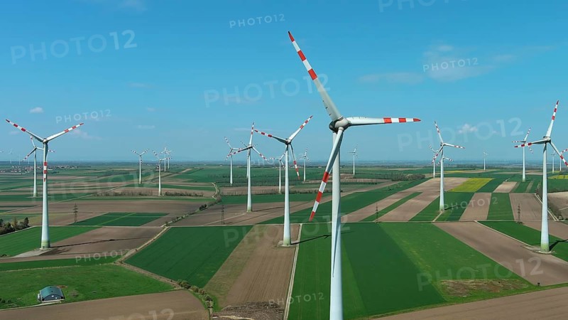 Aerial view of wind turbines and agriculture fields. Windmills turbines generating electricity, green energy