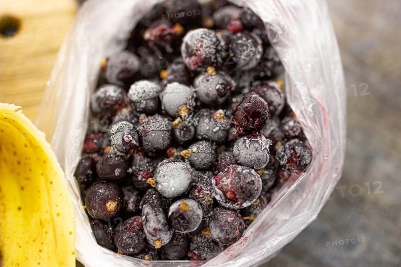 Bag of frozen blueberries covered in frost, giving a textured appearance