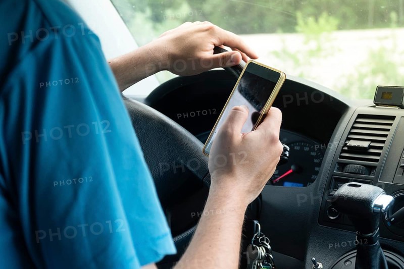 Photo of a man using smartphone while driving the car, transportation and vehicle concept with icon social media send email wifi chat read email