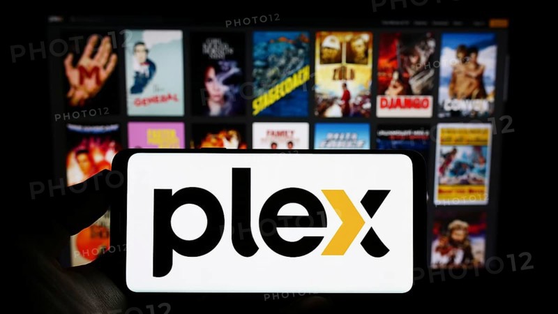 Stuttgart, Germany, 01-14-2023: Person holding mobile phone with logo of American video streaming company Plex Inc. on screen in front of web page. Focus on phone display, Europe