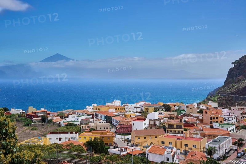 The village of Agulo, behind Tenerife and the Teide in clouds, Agulo, La Gomera, Canary Islands, Spain, Europe