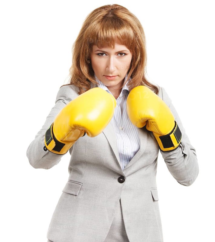 Portrait of a young businesswoman wearing boxing gloves