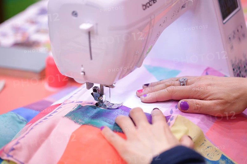 Sewing machine with hands of the seamstress at Creativeworld Frankfurt