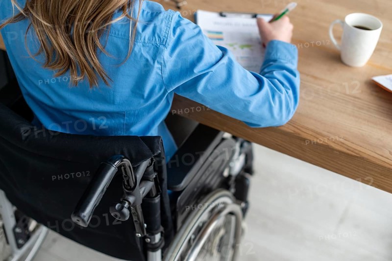 Close up woman wheelchair working office