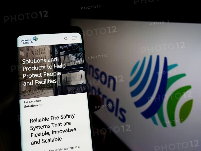 Stuttgart, Germany, 03-12-2022: Person holding cellphone with webpage of company Johnson Controls International plc (JCI) on screen with logo. Focus on center of phone display, Europe