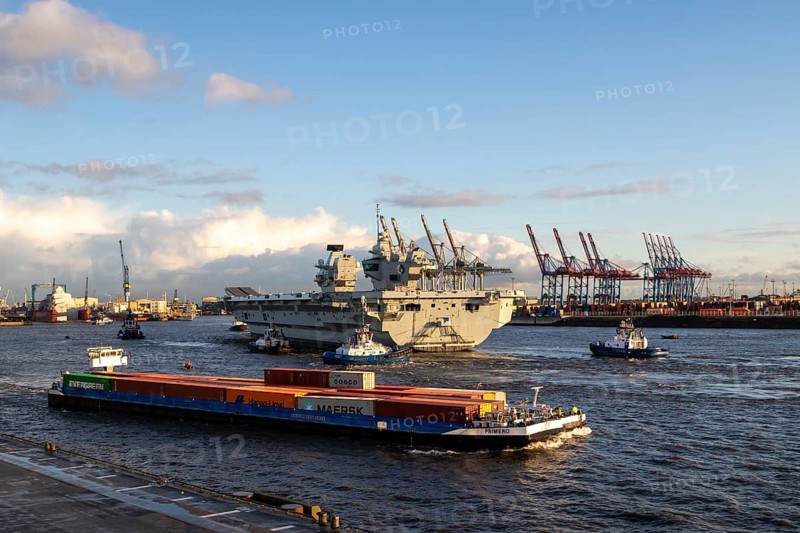 Freighter and aircraft carrier HMS Queen Elizabeth, warship of the British Royal Navy on the river Elbe arriving for a NATO exercise in the harbour of Hamburg, Germany, Europe