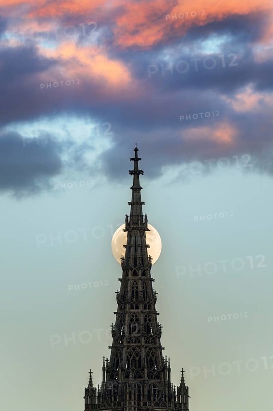 Full moon behind the minster of Ulm at sunset
