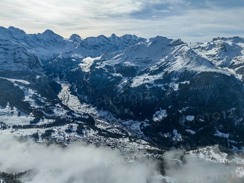 Lauterbrunnen Valley and Snowy Mountains in Winter. Swiss Alps. Switzerland. Aerial View over Clouds. View from Mannlichen Top