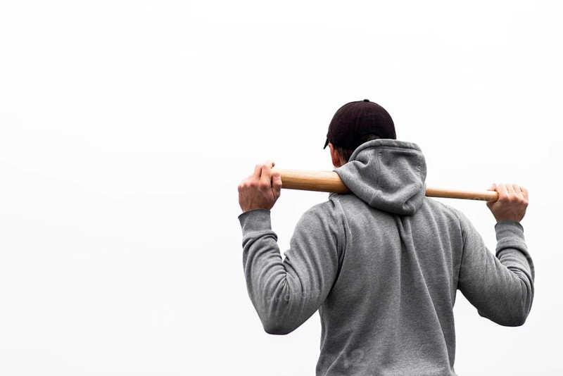 Back view man holding baseball bat shoulders