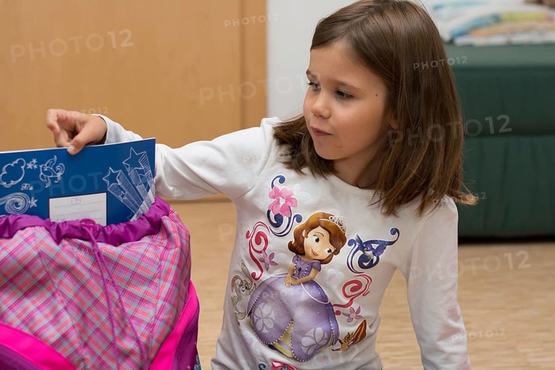 Child shows notebook from her first school bag, Austria, Europe