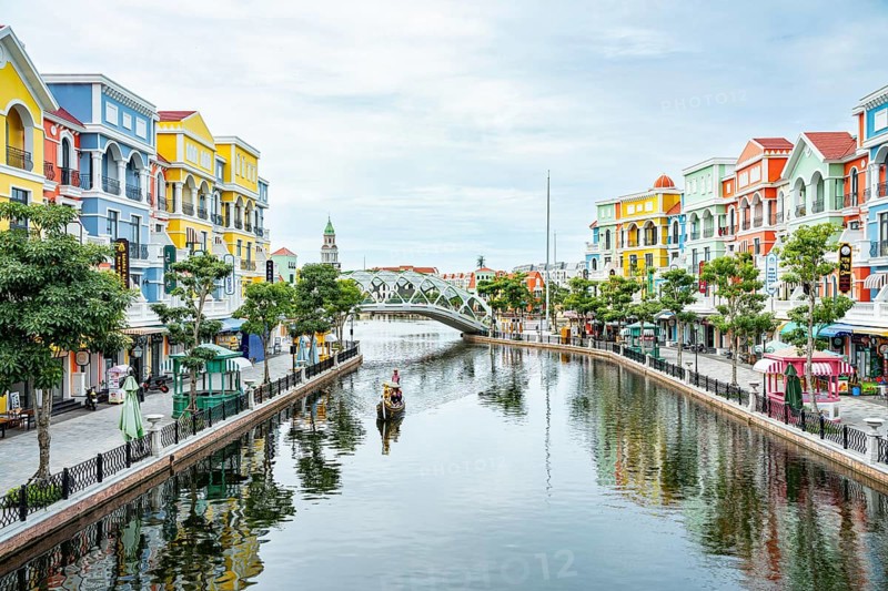 Vibrant buildings and a bridge reflected in a calm river under a clear sky, park, venice copy city, Grand World Phu Quoc, Vietnam, Asia