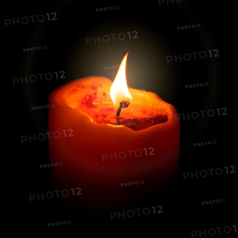 An image of a red candle in the dark