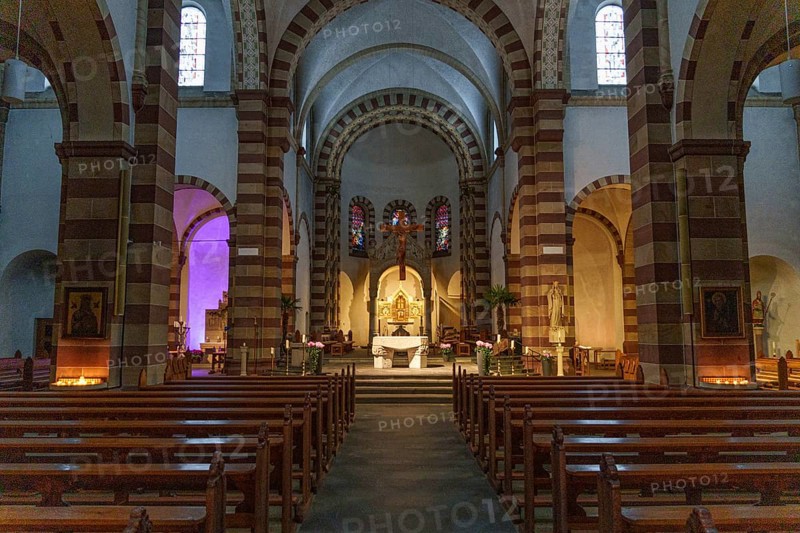 Interior view of an old church with imposing vaults and a central altar, surrounded by pews and stained glass windows, ankum, Lower Saxony, Germany, Europe