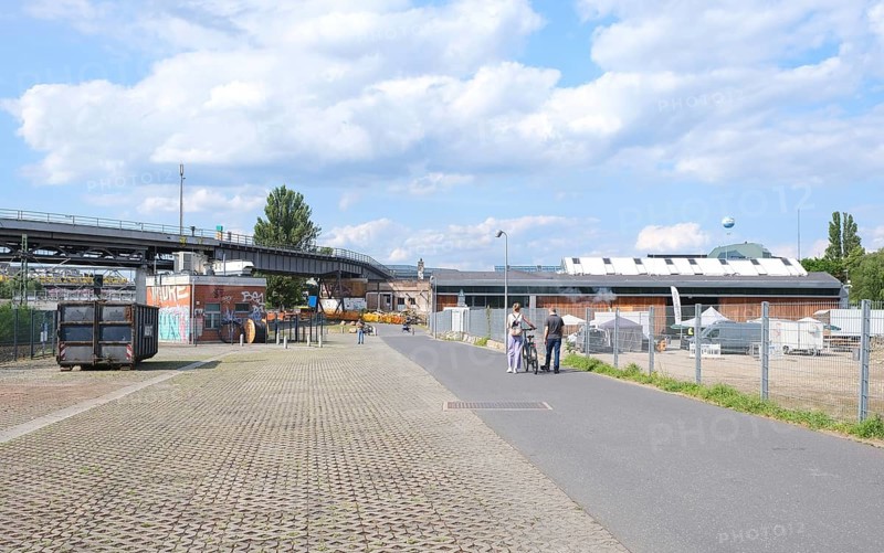 Berlin, Germany, July 14, 2023, summer scene in Park am Gleisdreieck with foot and bike path, elevated railway line and factory buildings, Europe