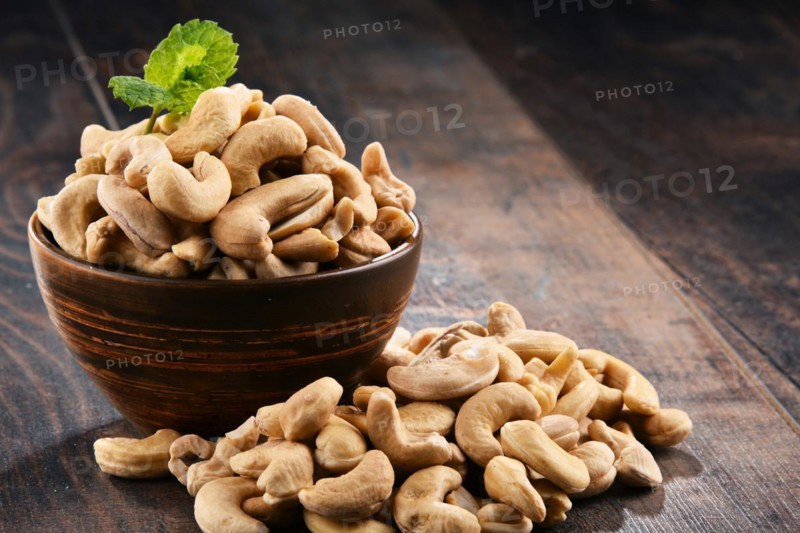 Bowl with cashew nuts on wooden table. Delicacies