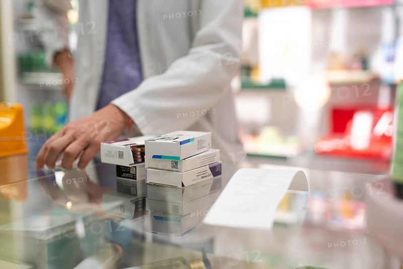 Medications stacked on a pharmacy counter, ready to be sold. Represents a typical scene in the daily routine of a pharmacy