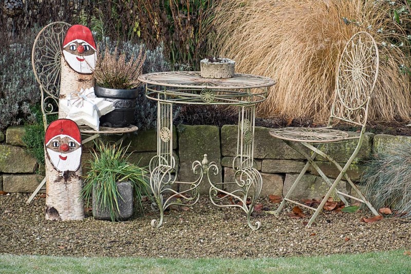 Iron garden furniture and Christmas gnome decorations on a gravel path, borken, North Rhine-Westphalia, germany