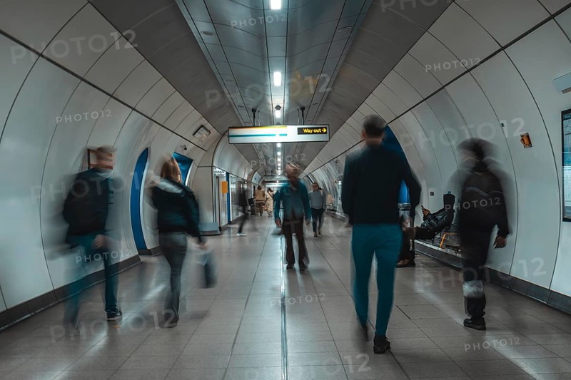 Tourists and commuters navigating an underground corridor in london, united kingdom, surrounded by modern architecture and vibrant energy